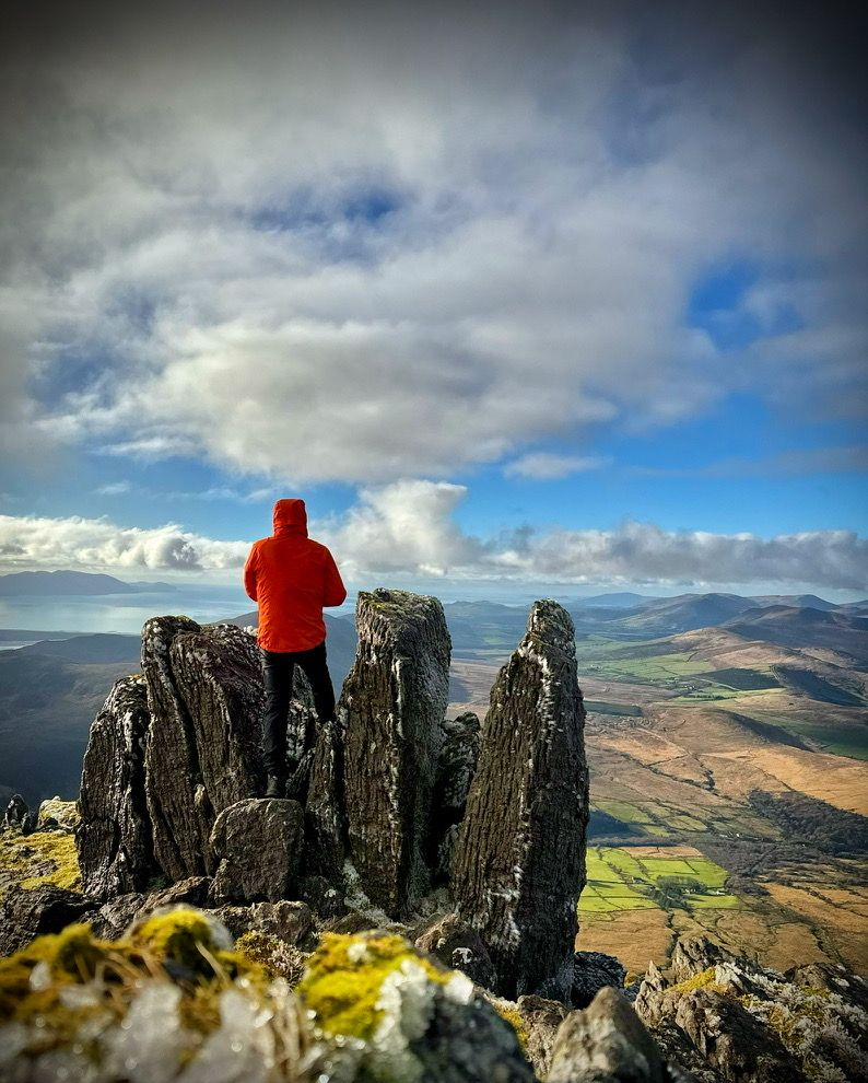 Rob Condon standing among rocky pinnacles high above the Kerry landscape