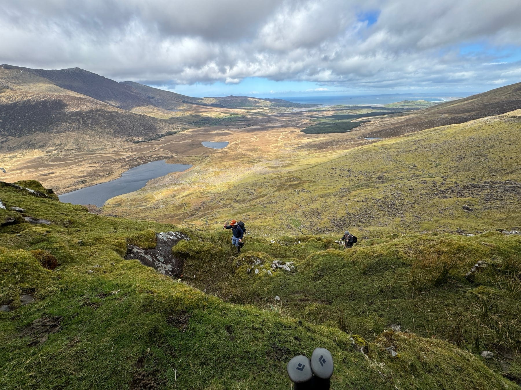 Walkers descending into a broad mountain valley