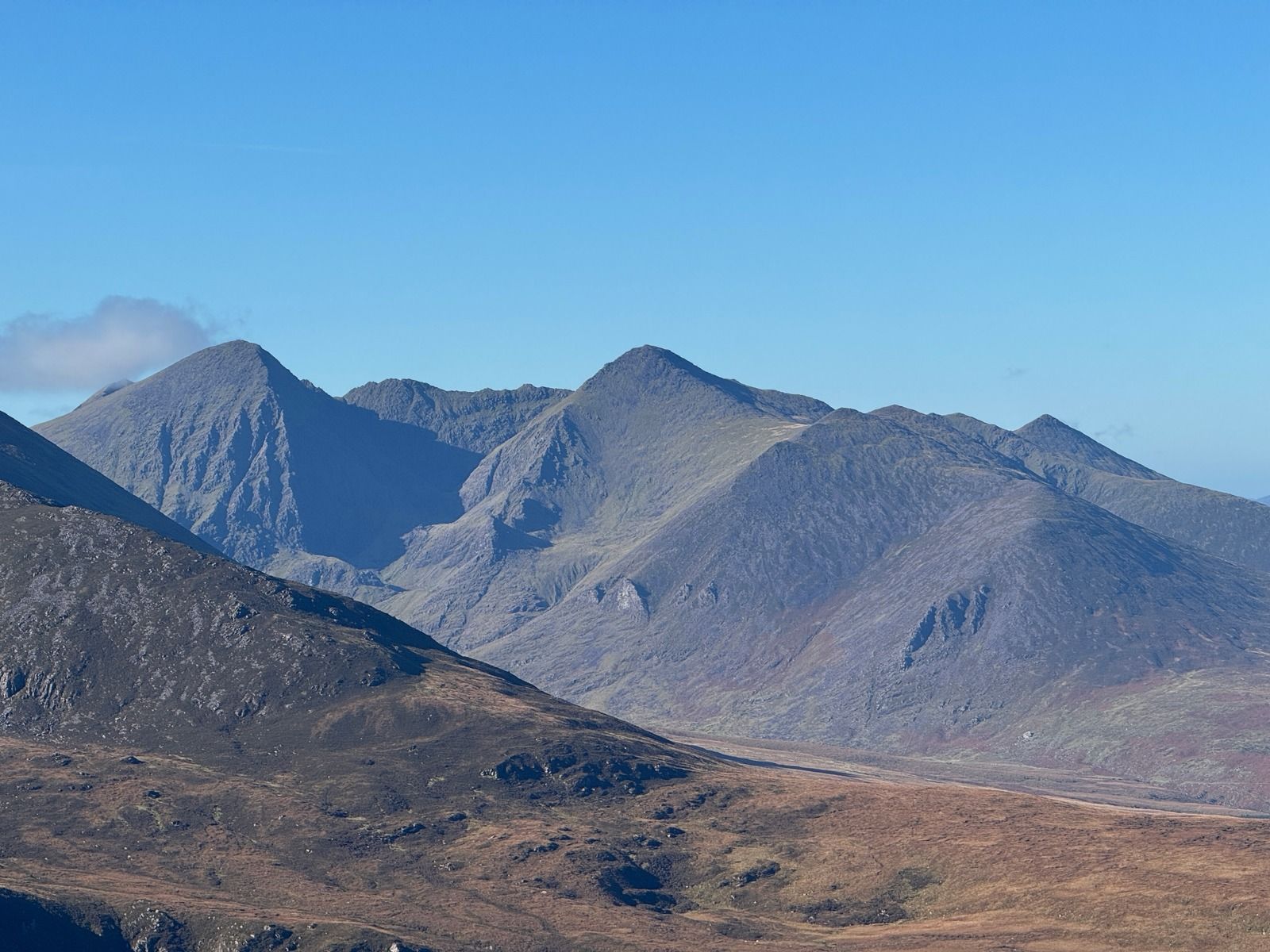 Sharp mountain peaks and ridges above a brown valley floor