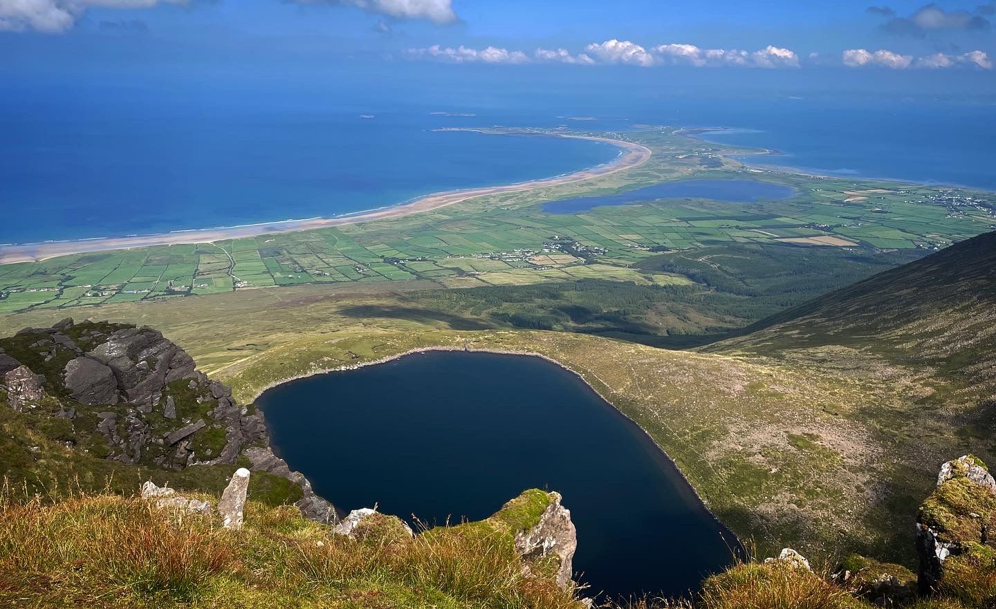 A close view into the corrie lough with the long curve of Brandon Bay beyond