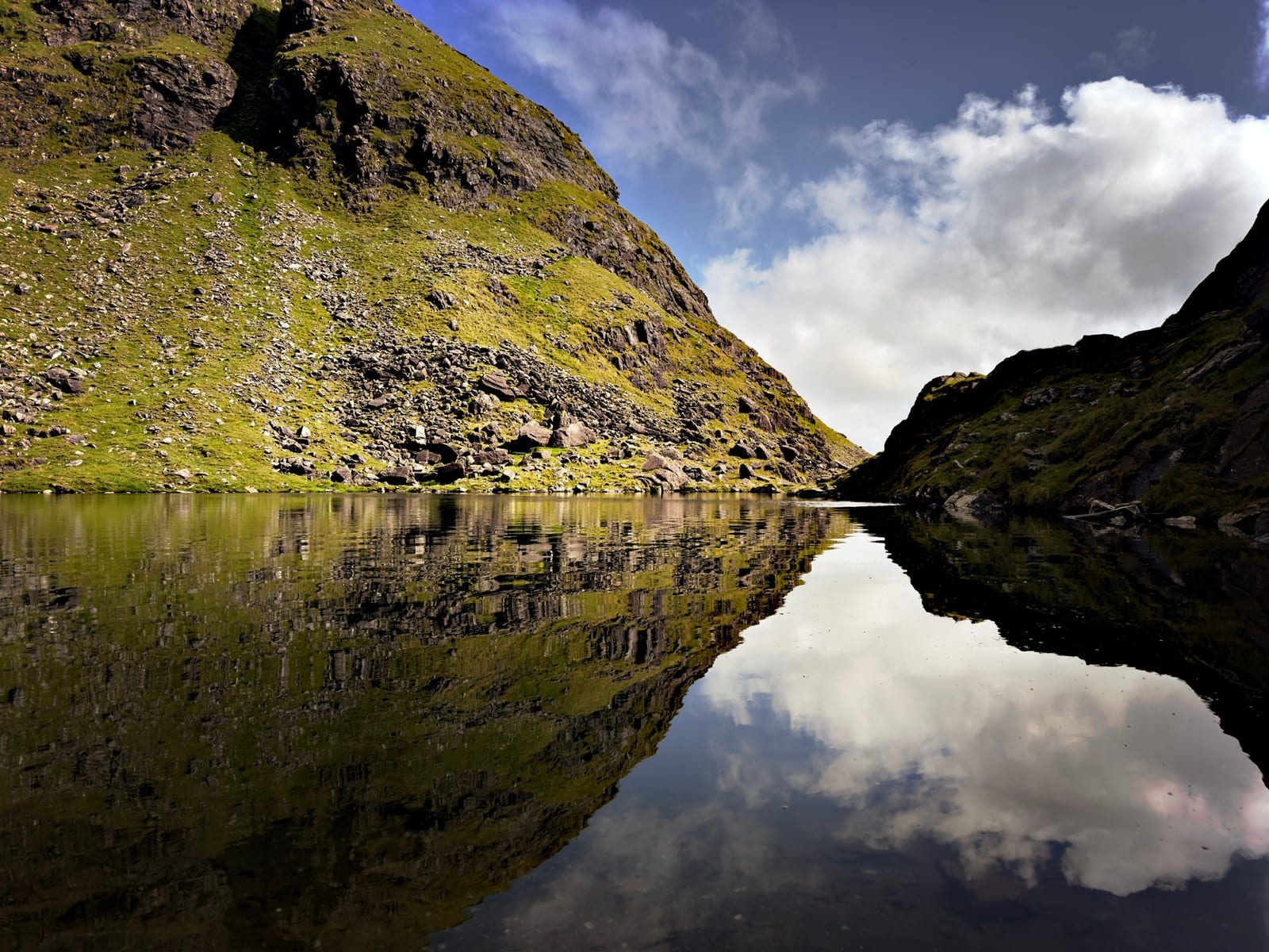A mountain lough reflecting steep green slopes