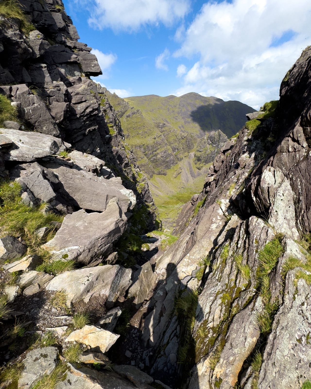Looking through a steep rocky gully towards the mountain ridge