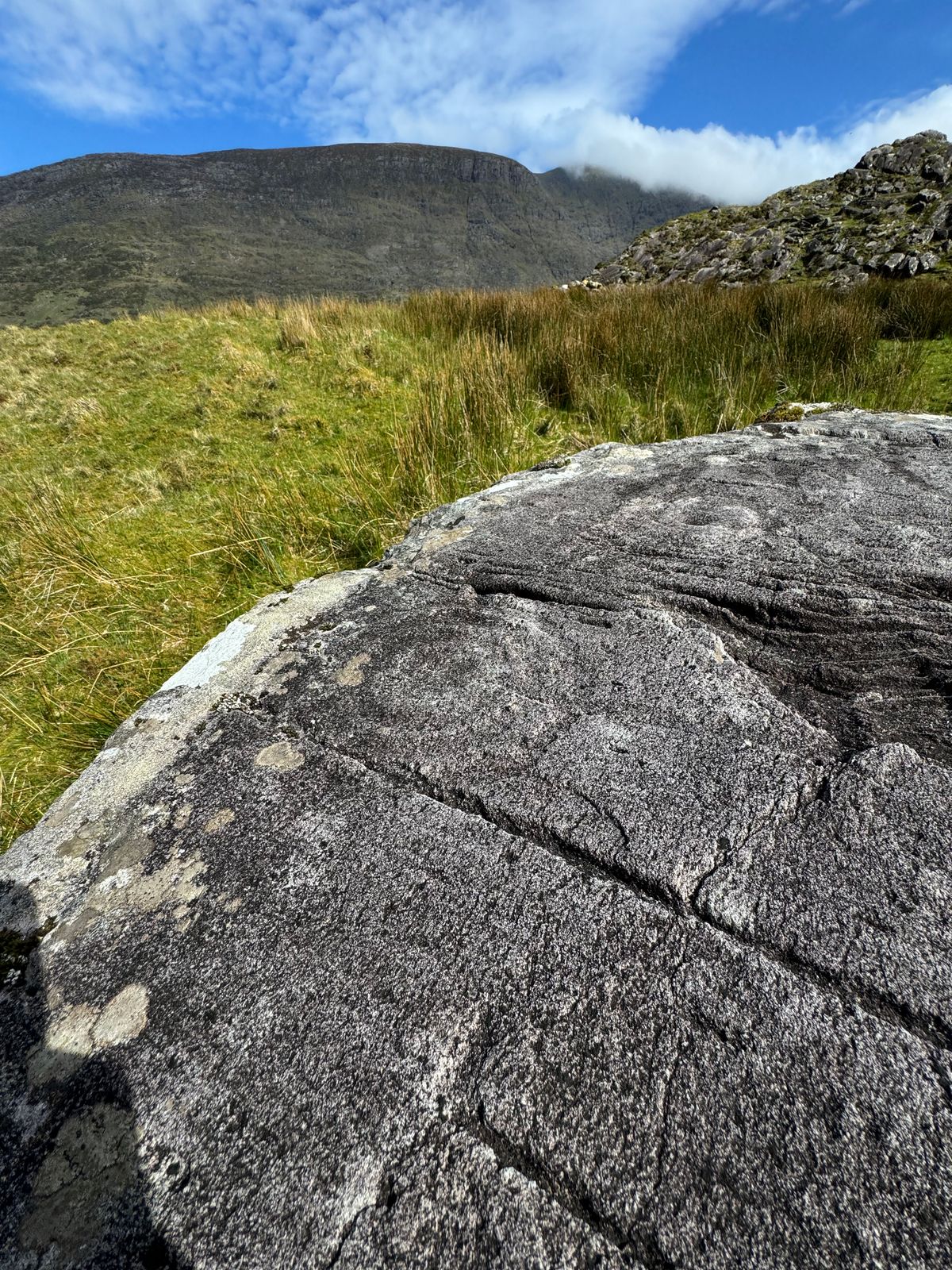 Weathered carved lines visible across the surface of the rock at Leaba na Bó