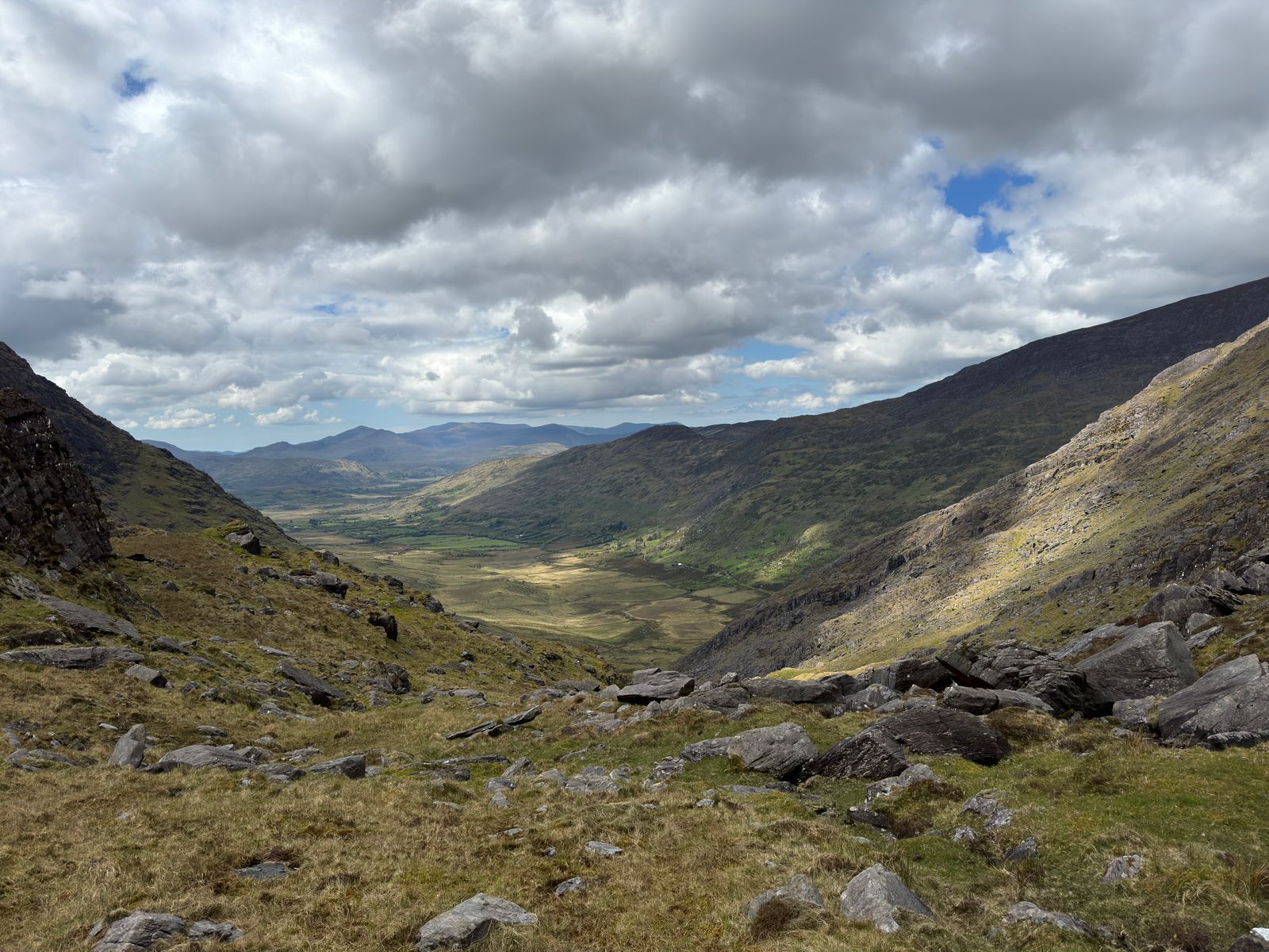 A long view from the mountain gully towards the green valley below