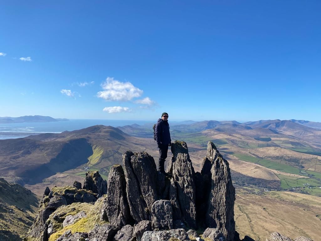 A walker standing among the sharp rock towers of the high ridge