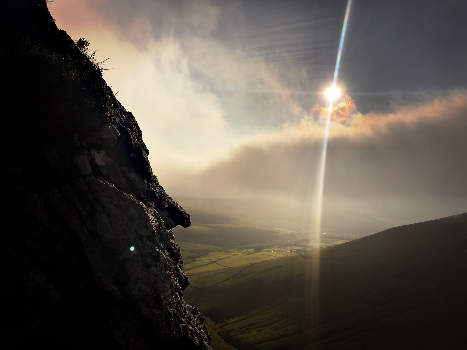 Low sun and mist beside a dark steep cliff above Doire Mór