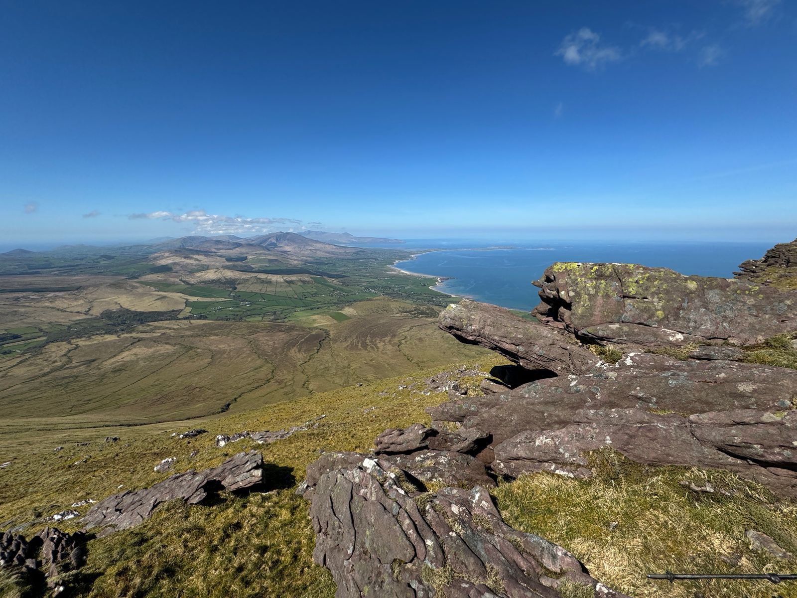 Layered sandstone in the foreground above the long shore of Tralee Bay