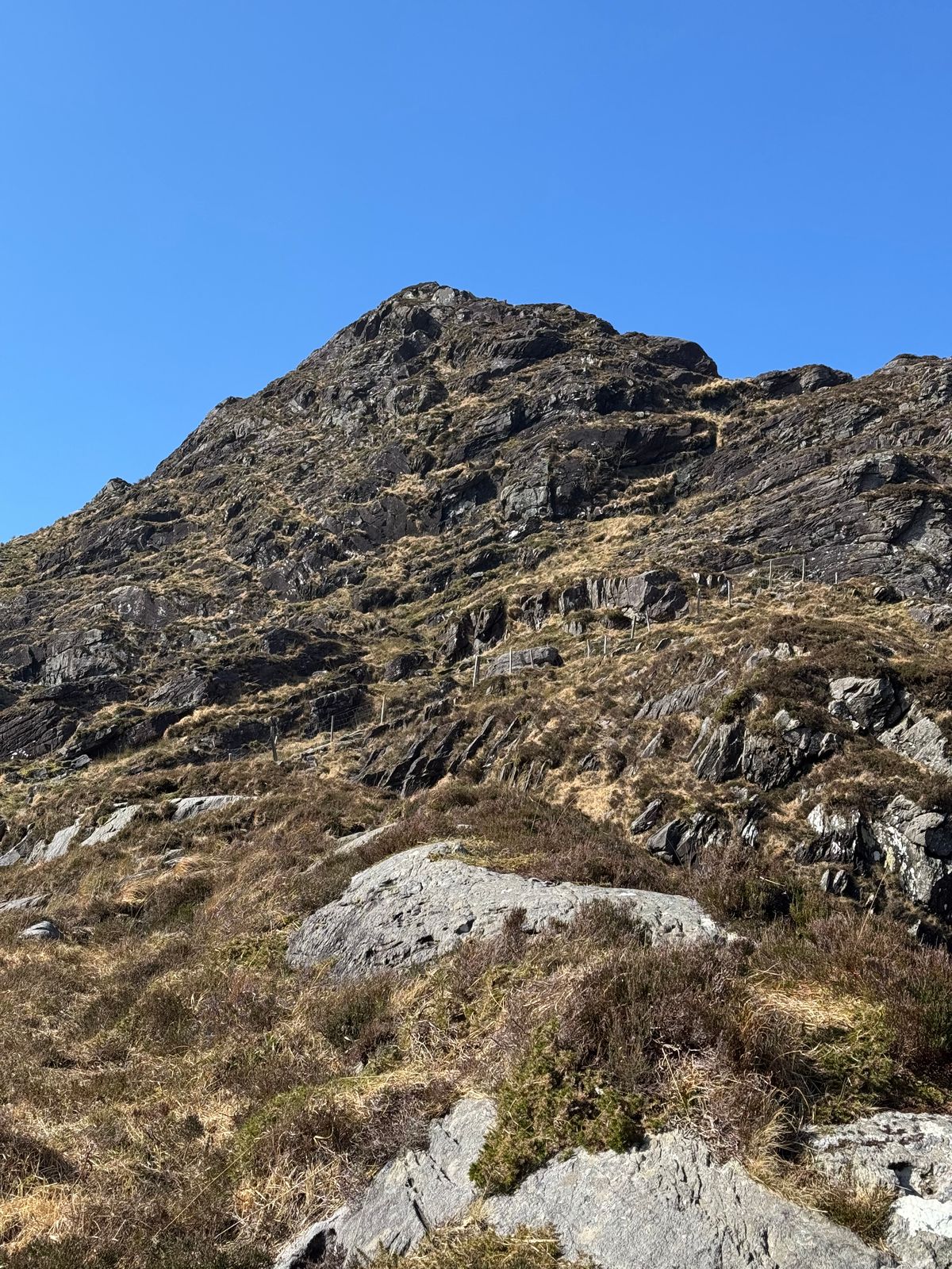 Steep broken rock and grass on the ascent of Cnoc na dTarbh