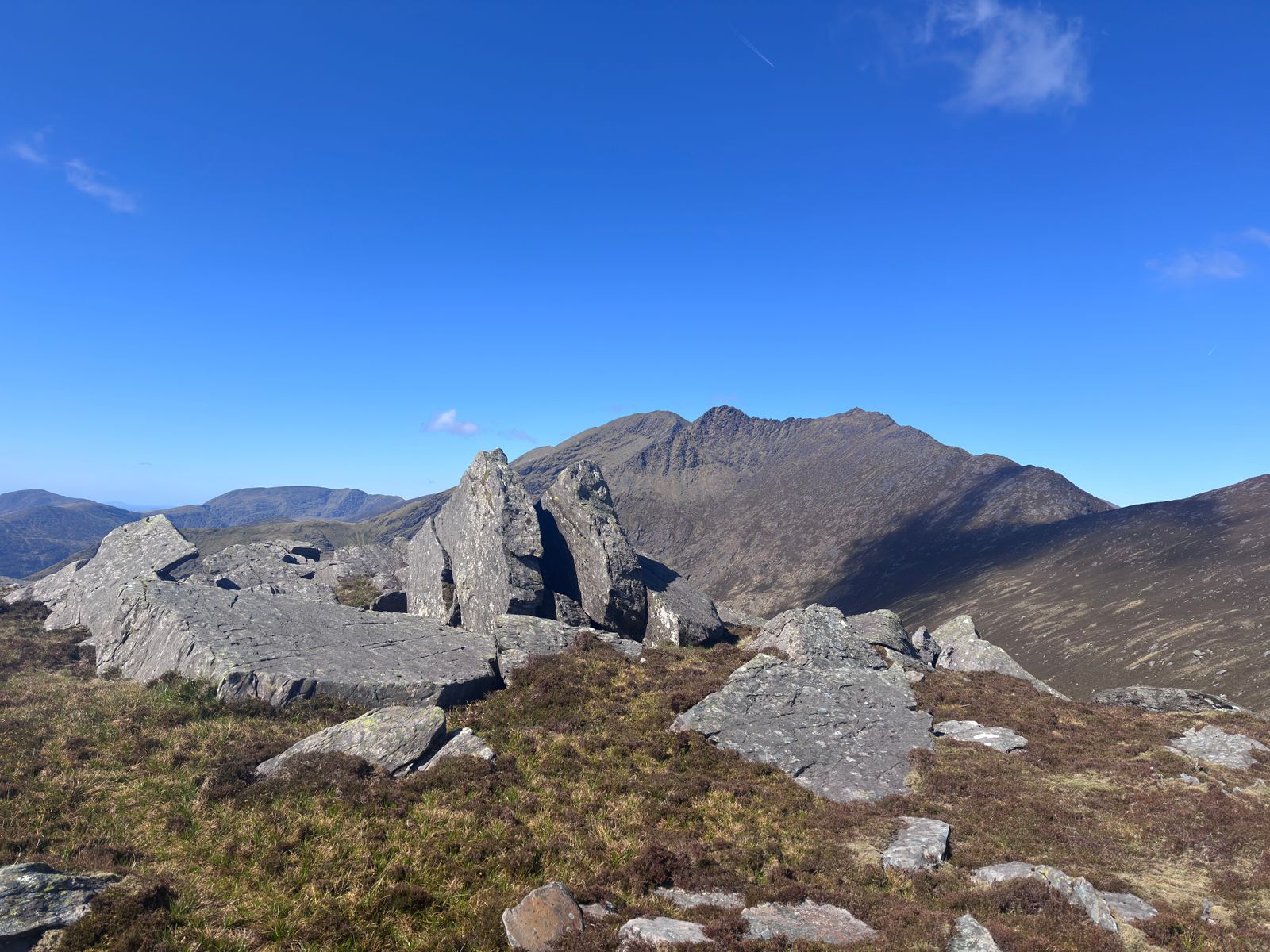A rough stone shelter with mountain ridges beyond