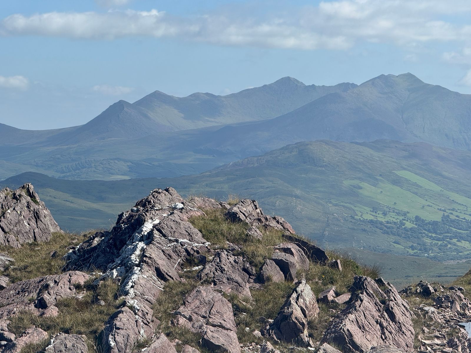 The MacGillycuddy’s Reeks rising beyond broken rocky ground