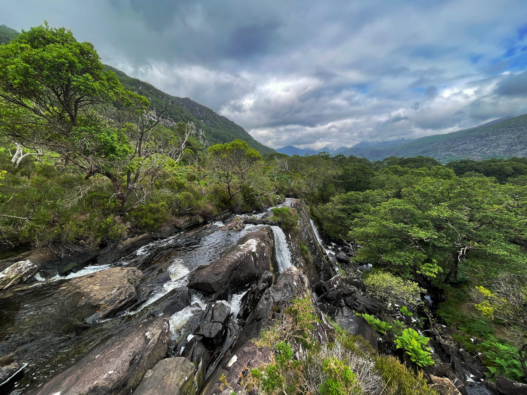 Fast water flowing over rock with the mountain valley beyond