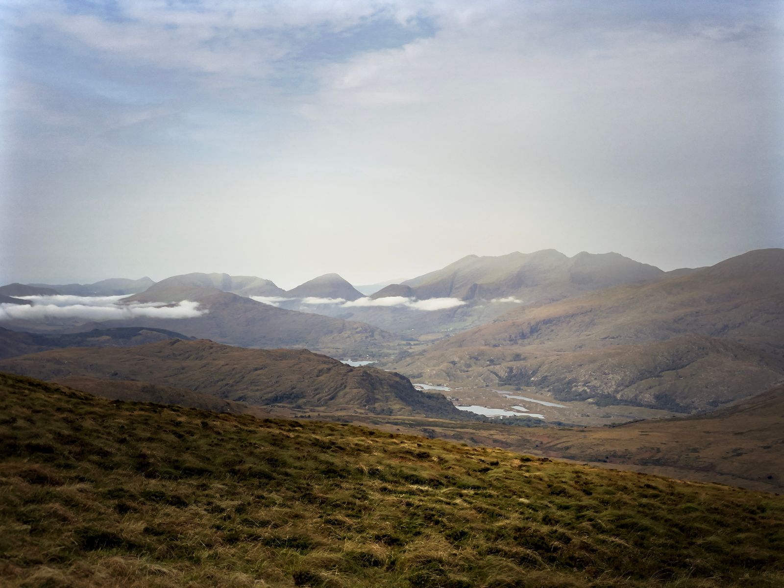 The distant Reeks rising beyond open moorland and bands of low cloud