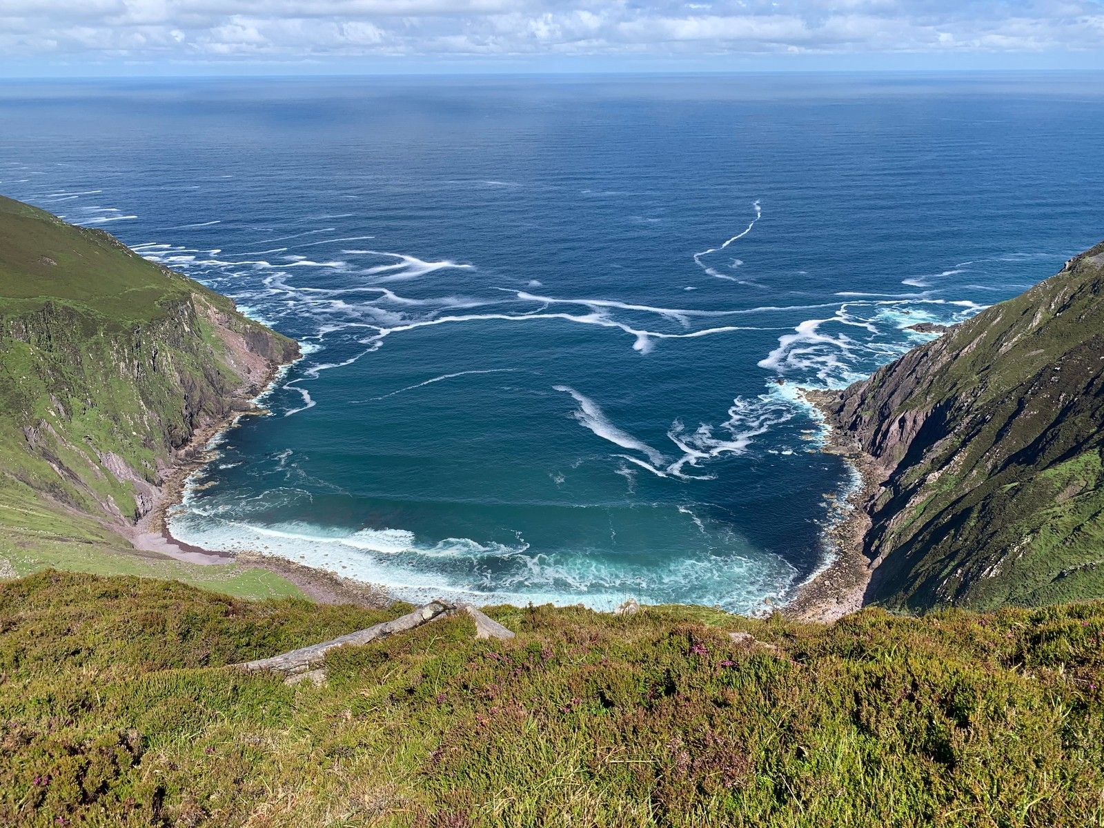 The steep-sided inlet of Sás Creek opening into the blue Atlantic
