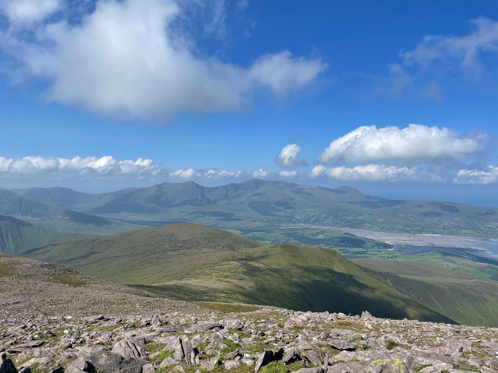 A panorama of green Dingle mountains beneath scattered white clouds
